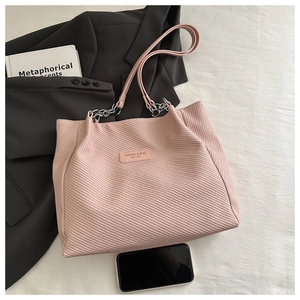 Détail du sac cabas en velours côtelé rose avec chaîne argentée et logo mode