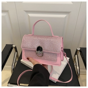 Close-up of pink sequined flap and silver metallic clasp on elegant crossbody bag