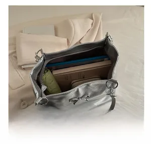 Macro detail of large silver tote bag interior showing ample storage for a tablet and wallet