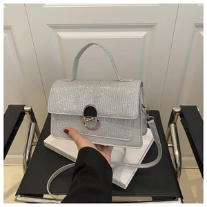 Detail view of silver crossbody bag with sparkling sequin panel and metal buckle clasp
