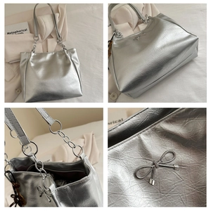 Detail of silver metallic tote bag featuring a textured finish and metal bow decoration