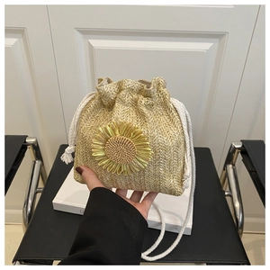 Detail view of woven straw bucket bag with sunflower detail and white cotton drawstring