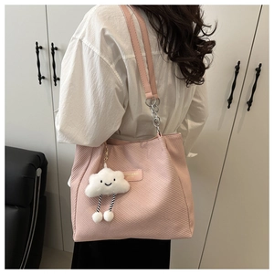 Pink tote bag detail with cute cloud charm and silver chain strap on model's shoulder