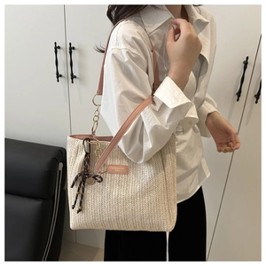 Borsa tote intrecciata beige con spalline rosa e foulard di seta indossata dal modello