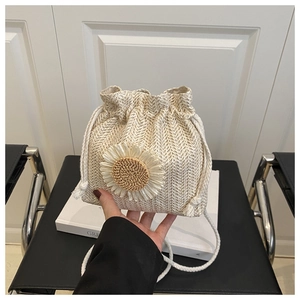 Detail of straw woven bucket bag with sunflower decor and cotton rope drawstring