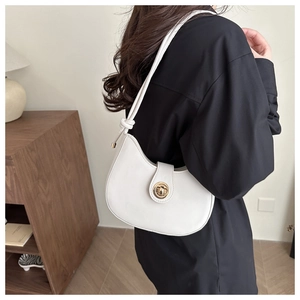 Detail of white minimalist crescent bag featuring a golden rotary lock and knotted strap