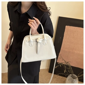 Lifestyle view of a white vintage square shoulder bag with a top handle and strap