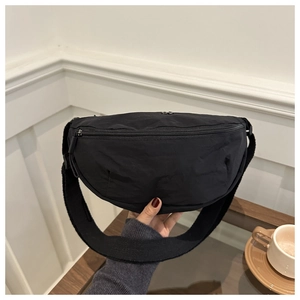 Detail der schwarzen Nylon-Halbmondtasche mit breitem Webriemen für Sportstil
