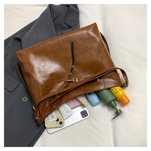 Flat lay of brown large capacity tote bag showing spacious interior with iPad and cosmetics