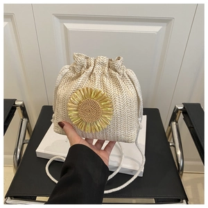 Detail of cream woven bucket bag with 3D yellow sunflower and white drawstring straps