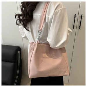 Macro detail of pink textured tote bag showing ribbed material and silver chain strap