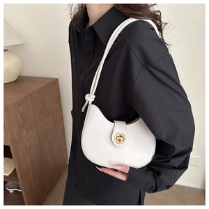 Détail du sac croissant blanc avec fermoir rotatif doré et bandoulière à nœud