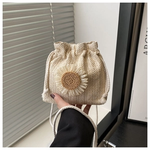 Gros plan du sac seau tissé avec décor de tournesol et texture de paille tressée