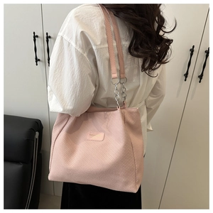 Detail of pink corduroy tote bag showing textured fabric and silver chain leather strap