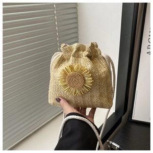 Détail du sac seau en paille tressée avec grande fleur de tournesol et cordon de serrage