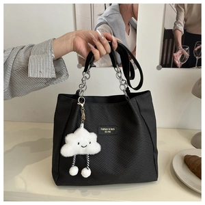 Détail du sac cabas noir avec texture diagonale et pendentif nuage en peluche