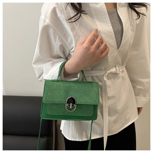 Detail of emerald green mini square bag with glitter flap and silver swivel lock clasp