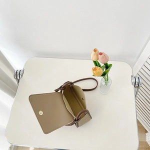 Minimalist beige crossbody square bag with brown trim shown from a 45-degree angle