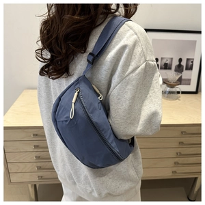 Nahaufnahme der blau-grauen Nylon-Satteltasche mit verstellbarem Riemen am Model zu Hause