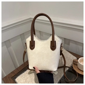 Detail of contrast bucket bag in cream and brown with Fashion & Bags text on desk