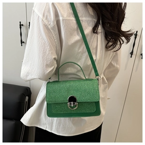 Rear view of a model wearing a bright green woven mini bag with silver metal twist lock