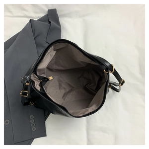 Detail of black PU leather tote interior with zipper pocket and golden hardware