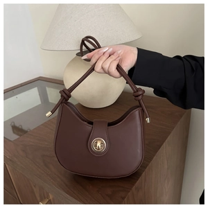 Détail d'un sac sous les aisselles demi-lune marron foncé avec fermoir doré rotatif