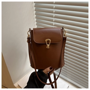 Detail view of brown vintage bucket bag with unique gold lock and smooth PU leather texture