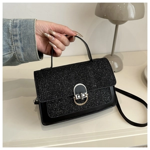 Detail view of the black glitter textured fabric and silver U-shaped metal lock on the bag