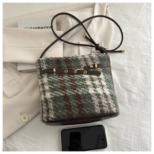 Top view of retro plaid tweed bucket bag with dark brown leather straps and metal details