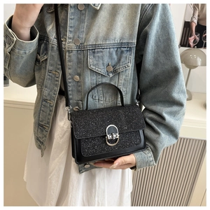 Chic black mini bag with silver twist-lock closure shown styled on a denim jacket outfit