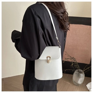 Vue arrière du mannequin portant un sac bandoulière blanc avec boucle en fer à cheval