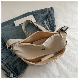 Innenansicht der beigen Nylon-Umhängetasche mit geräumigen Innentaschen und Futterdesign