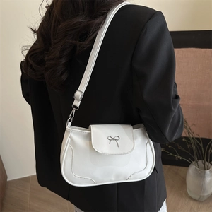 White PU leather crossbody bag with a metal bow accent and adjustable shoulder strap