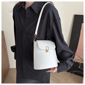 Detail of white leather shoulder bag with elegant gold buckle and clean stitching
