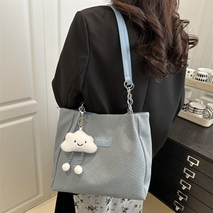 Sac cabas en velours côtelé bleu clair avec pendentif nuage porté par un mannequin