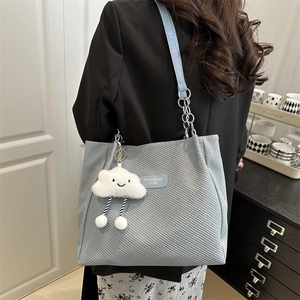 Sac fourre-tout bleu clair en velours avec bandoulière et charm nuage sur modèle