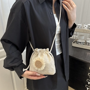 Sac seau tissé beige avec fleur de tournesol et cordon, idéal pour les vacances d'été à la mer