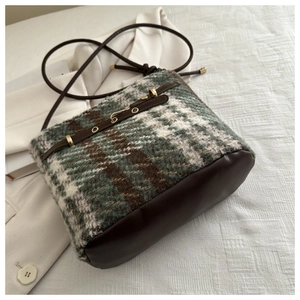 Close-up of vintage plaid wool bucket bag with premium brown leather splicing and strap