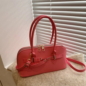Detail view of pink bowling bag with gold buckle straps and dual metal zippers