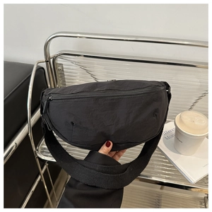 Detail der schwarzen Halbmondtasche aus Nylon mit Knitteroptik und breitem Schultergurt