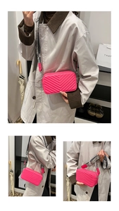 Vue détaillée du sac à bandoulière rose matelassé avec large sangle tissée noir et blanc