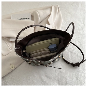 Top view of plaid tweed bucket bag interior showing spacious storage and leather handles