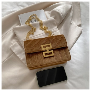 Detail of brown velvet crossbody bag with golden H clasp and chic chain strap