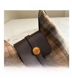 Detail of vintage plaid bag showing brown leather flap and golden N metal buckle closure