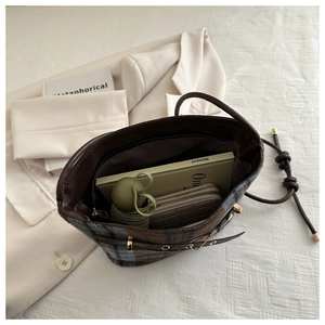 Detailed top view of plaid bucket bag interior showing large storage capacity space