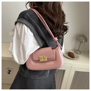 Detail of pink leather shoulder bag featuring a square gold buckle and knotted strap