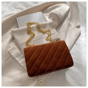 Detailed view of caramel brown quilted velvet bag with elegant gold chain strap