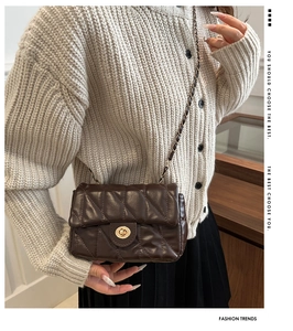 Detail view of coffee brown quilted crossbody bag with metal chain strap and turn-lock