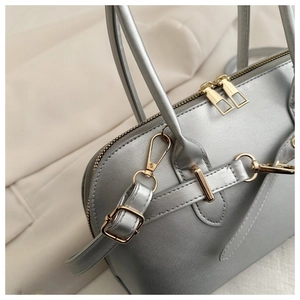 Detailed close-up of metallic silver bowling bag with golden hardware and straps